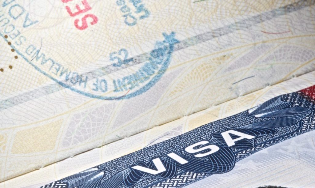 Google and Apple Warn Visa Workers to Pause International Travel Google and Apple logos with a U.S. visa stamp concept, illustrating warnings to visa-holding employees about international travel delays