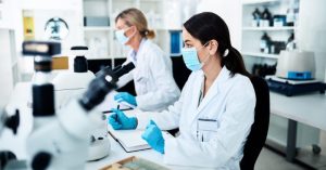 Laboratory researcher examining neuroscience data on a screen with molecular brain graphics in the background