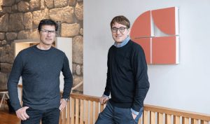 GuestReady and Lightbooking logos over a map of Spain representing an expansion of short-term rental properties