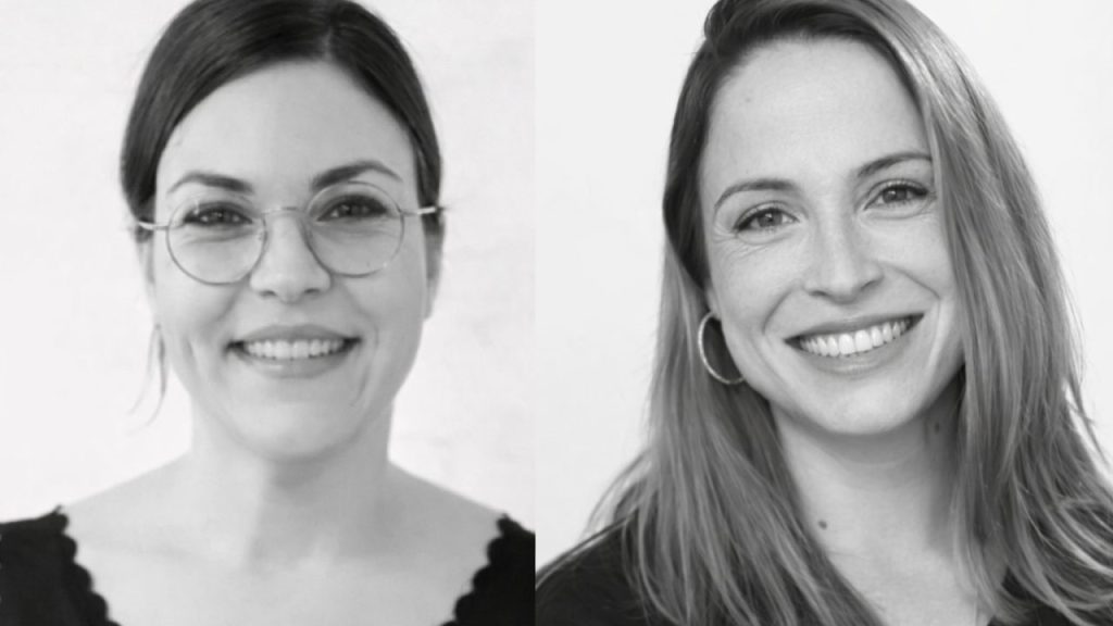 Female-founded startup team collaborating on a no-code SaaS application design interface on large screens in a modern office