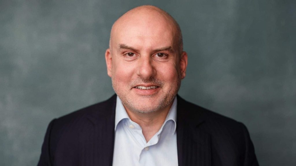 Team of AI InsurTech specialists collaborating in a modern UK office with insurance data dashboards on screens