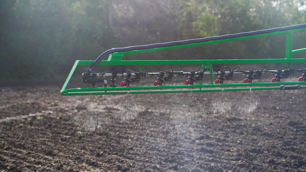 Farmer operating a tractor equipped with BBLeap precision spraying technology in a crop field