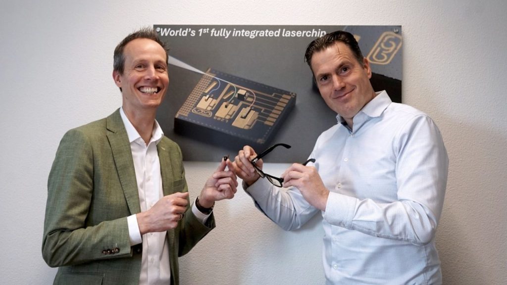 Engineers inspecting a photonic chip with integrated RGB laser technology in a cleanroom lab