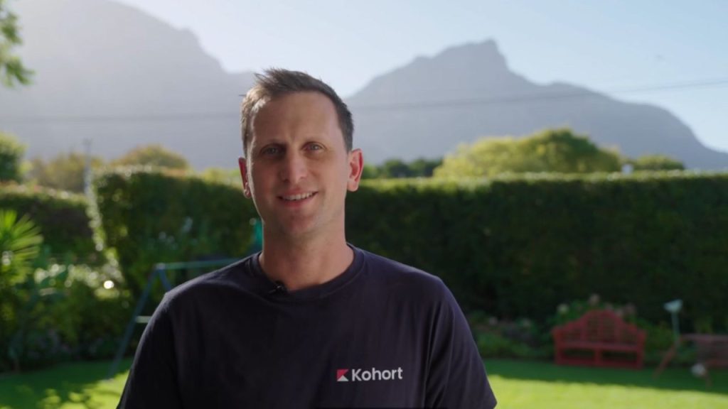 Kohort logo with a background of mobile game graphics.